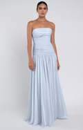 Woman wearing a light blue strapless gown against a white background